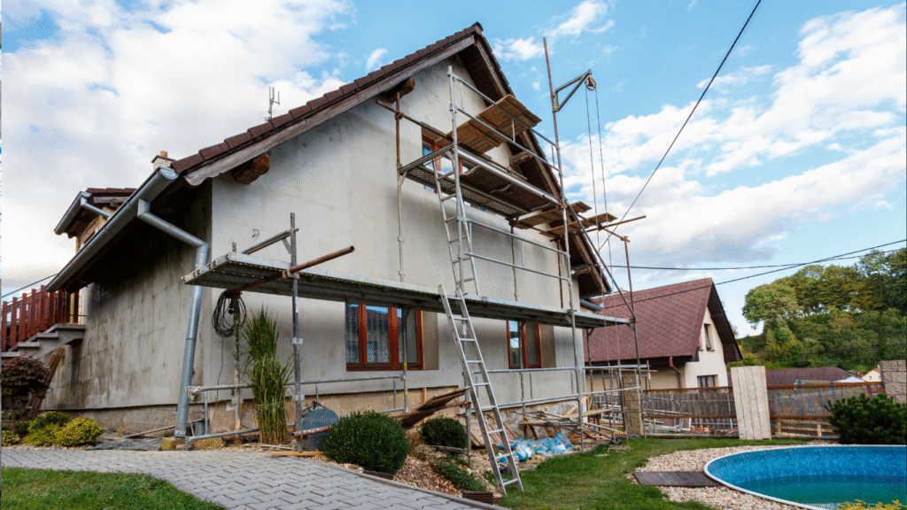 A house undergoing exterior renovation with scaffolding, showing construction or repair work.