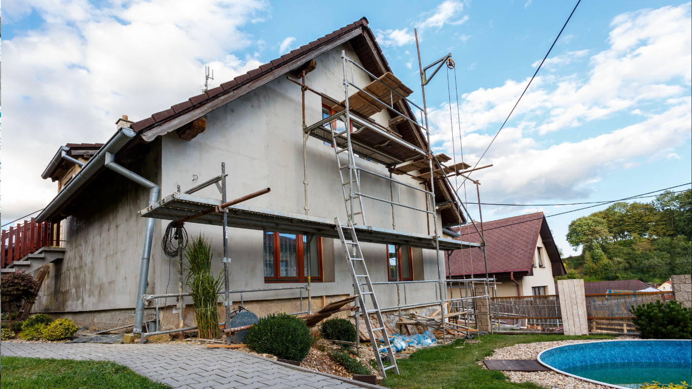 A house undergoing exterior renovation with scaffolding, showing construction or repair work.